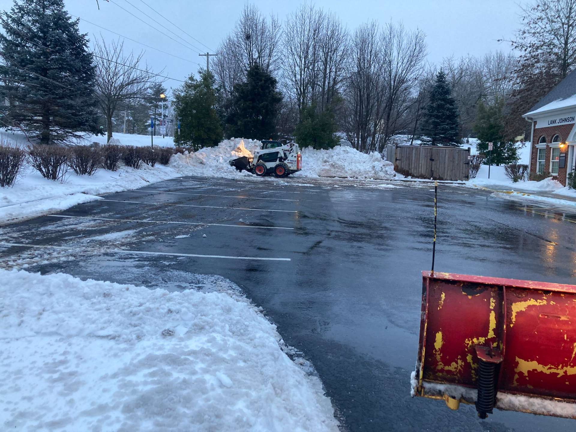Snow removal equipment clearing a parking lot