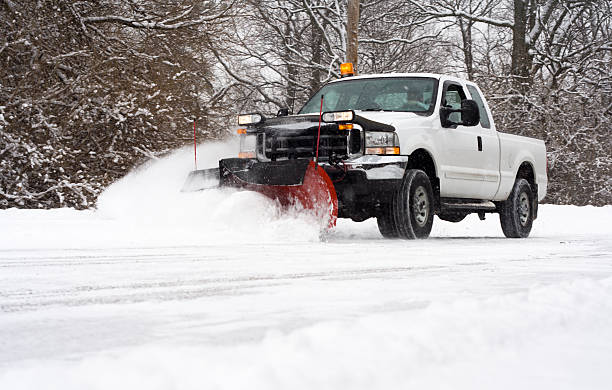 White pickup snowplow clearing fresh snow